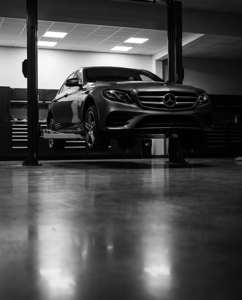 Lifte alınmış Mercedes-Benz E Serisi, servis atölyesinin içinden görünüyor